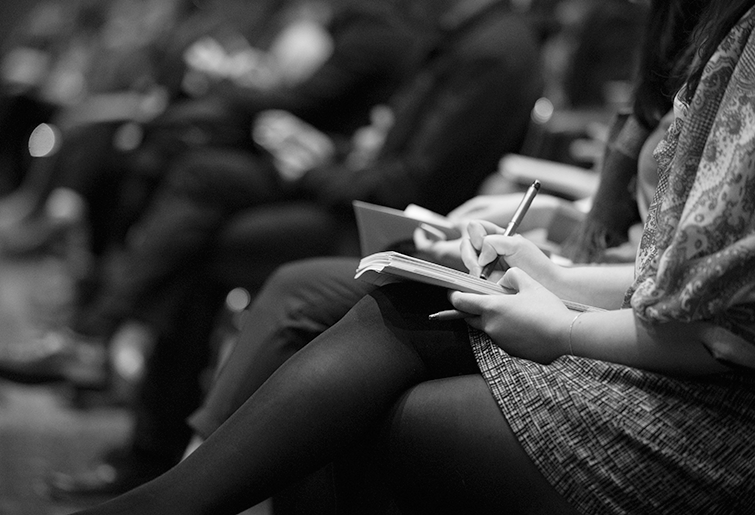 Journalists taking notes during press conference